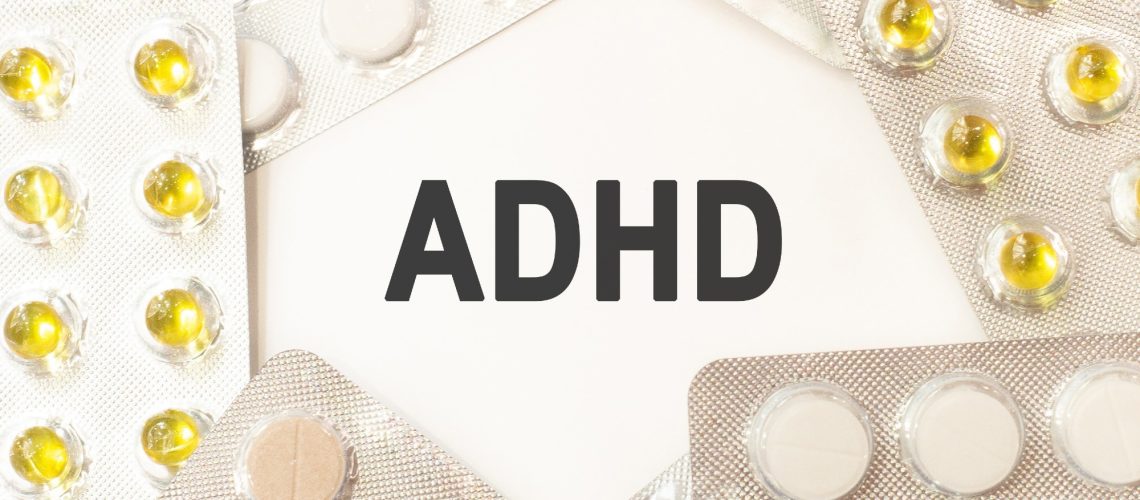 Text adhd on white background. There are various pills and vitamins around