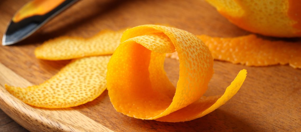 Orange peels on wooden cutting board